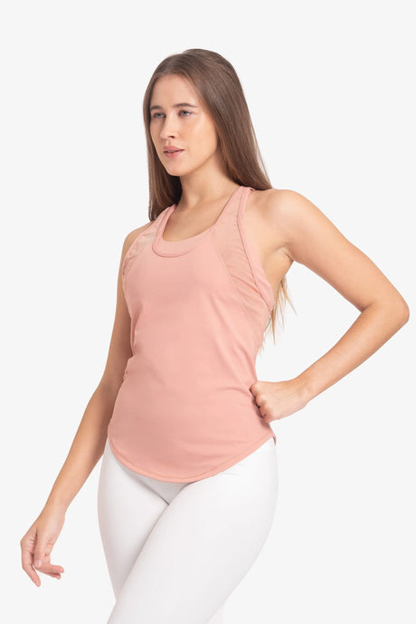 Mujer con camiseta deportiva rosa y leggings blancos, fondo blanco, ropa fitness femenina