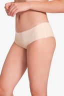 Primer plano de mujer usando ropa interior beige sin costuras, fondo blanco