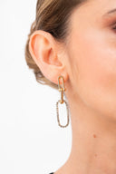 Pendiente dorado colgante con cristales en oreja de mujer con piel clara