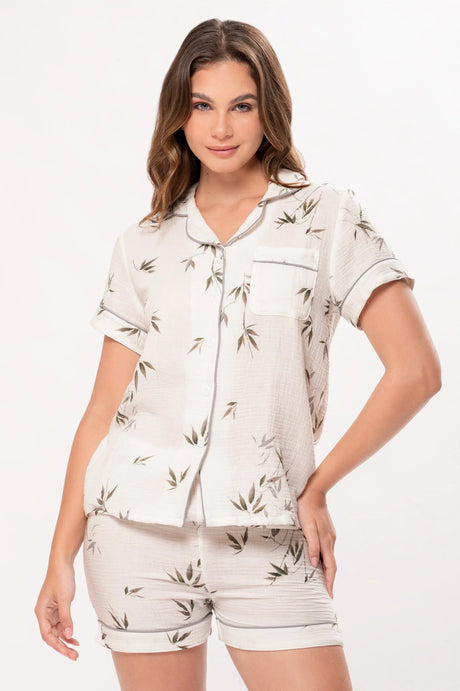 Mujer con pijama corto blanco con estampado de hojas verdes, fondo blanco