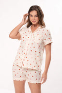 Mujer con pijama corto beige con estampado de pequeños corazones rojos y rosas, fondo blanco