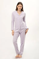 Mujer con pijama lila de botones y cuello solapa, fondo blanco